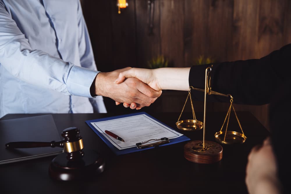 Client shakes hands with attorney after discussing a contract deal.