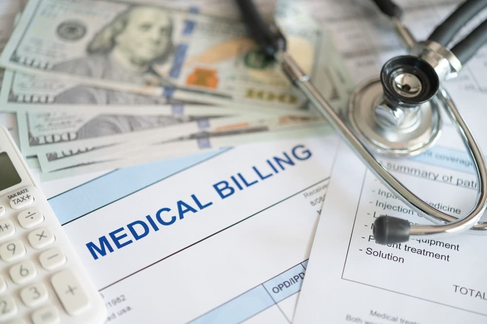 medical billing document and dollar banknote, calculator, stathoscope. medical treatment expense concept.