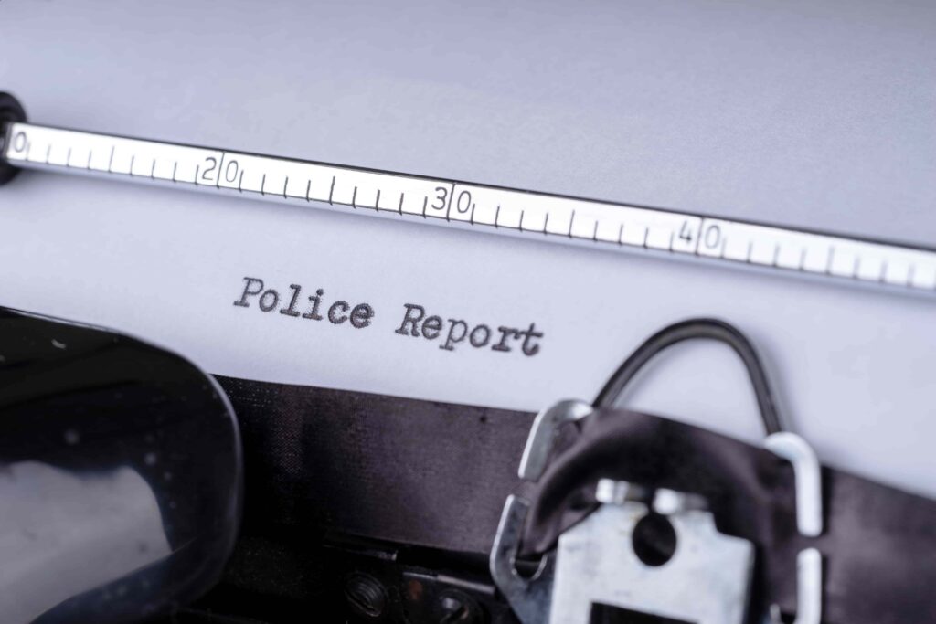 Close-up of a police report document with a measuring tape and handcuffs, representing a criminal investigation. Close-up of a police report document with a measuring tape and handcuffs, representing a criminal investigation.